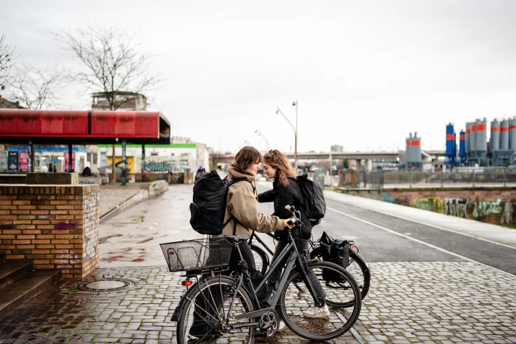 Zwei Personen stehen mit Fahrrädern an einer Straße im Mannheimer Hafen.
