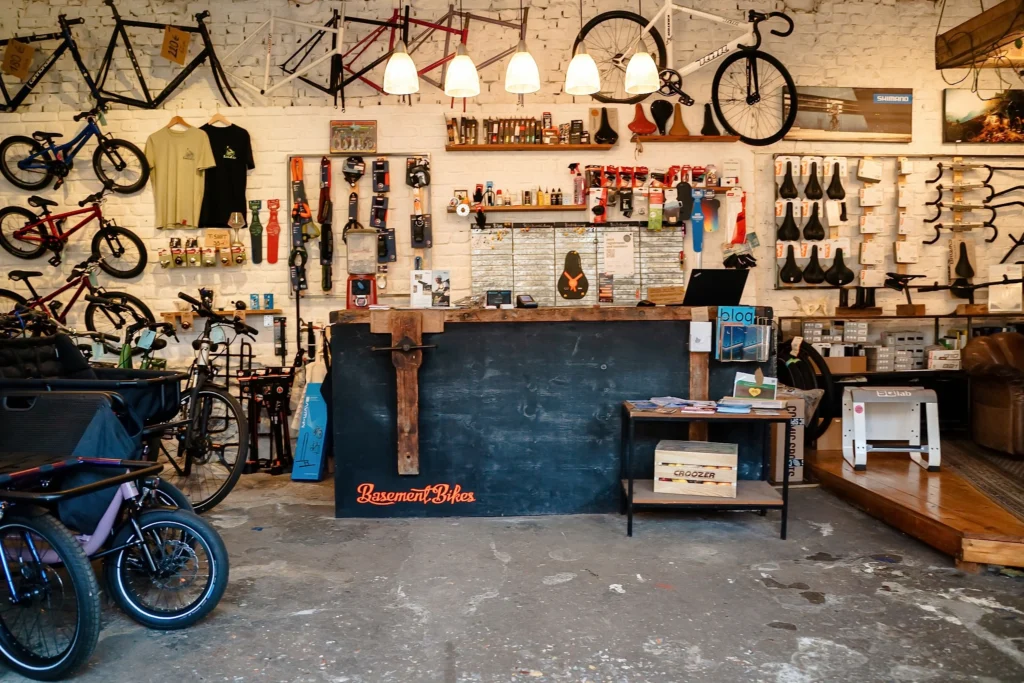 Der Verkaufsraum einer Fahrradwerkstatt mit ausgestellten Fahrrädern, Fahrradrahmen, Zubehör und einer Werkstatttheke.