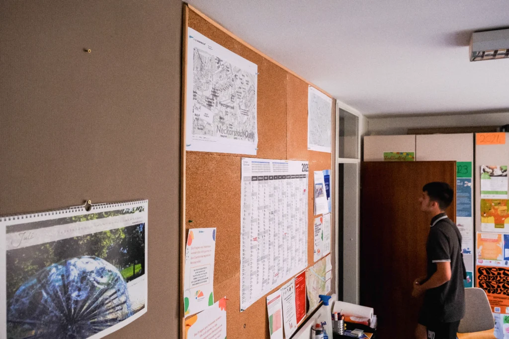 Eine Person betrachtet Informationen und Aushänge im Stadtteilbüro Herzogenried.