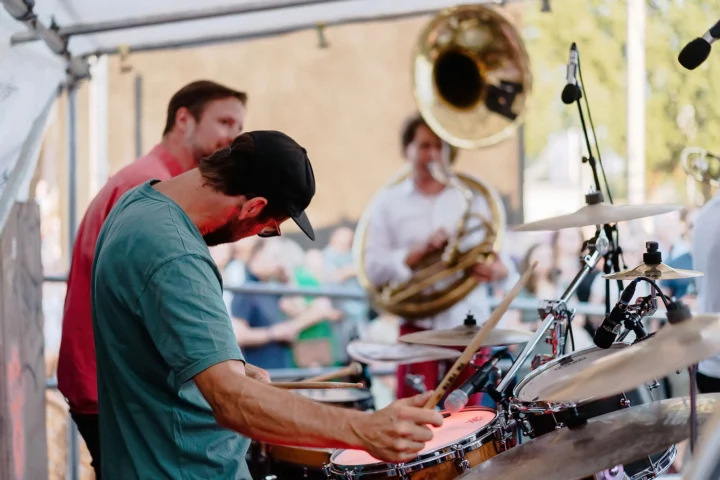 Eine Band sorgt bei einem Open-Air-Konzert für mitreißende Stimmung und zeigt die lebendige Musik- und Kulturszene Mannheims.